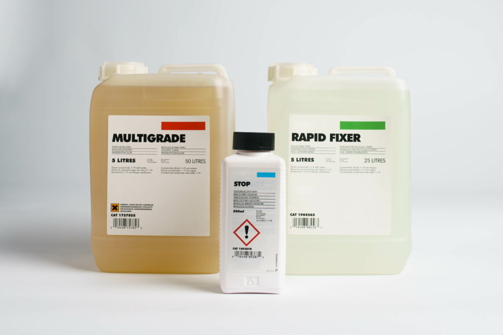 jugs of dark room chemicals; developer, fixer, stop bath